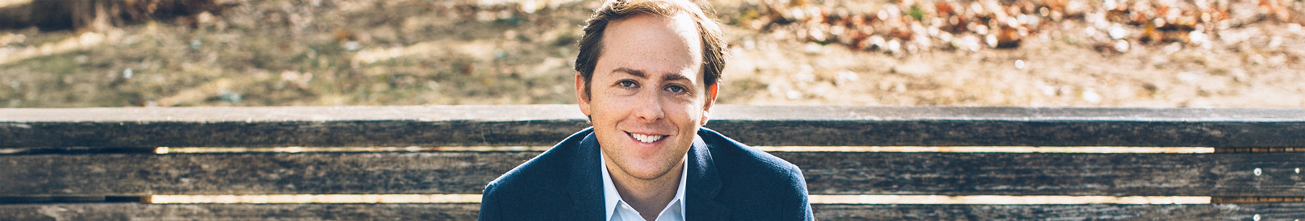 Image of SSSB Speaker David Litt, Political Analyst, sitting on a brown bench
